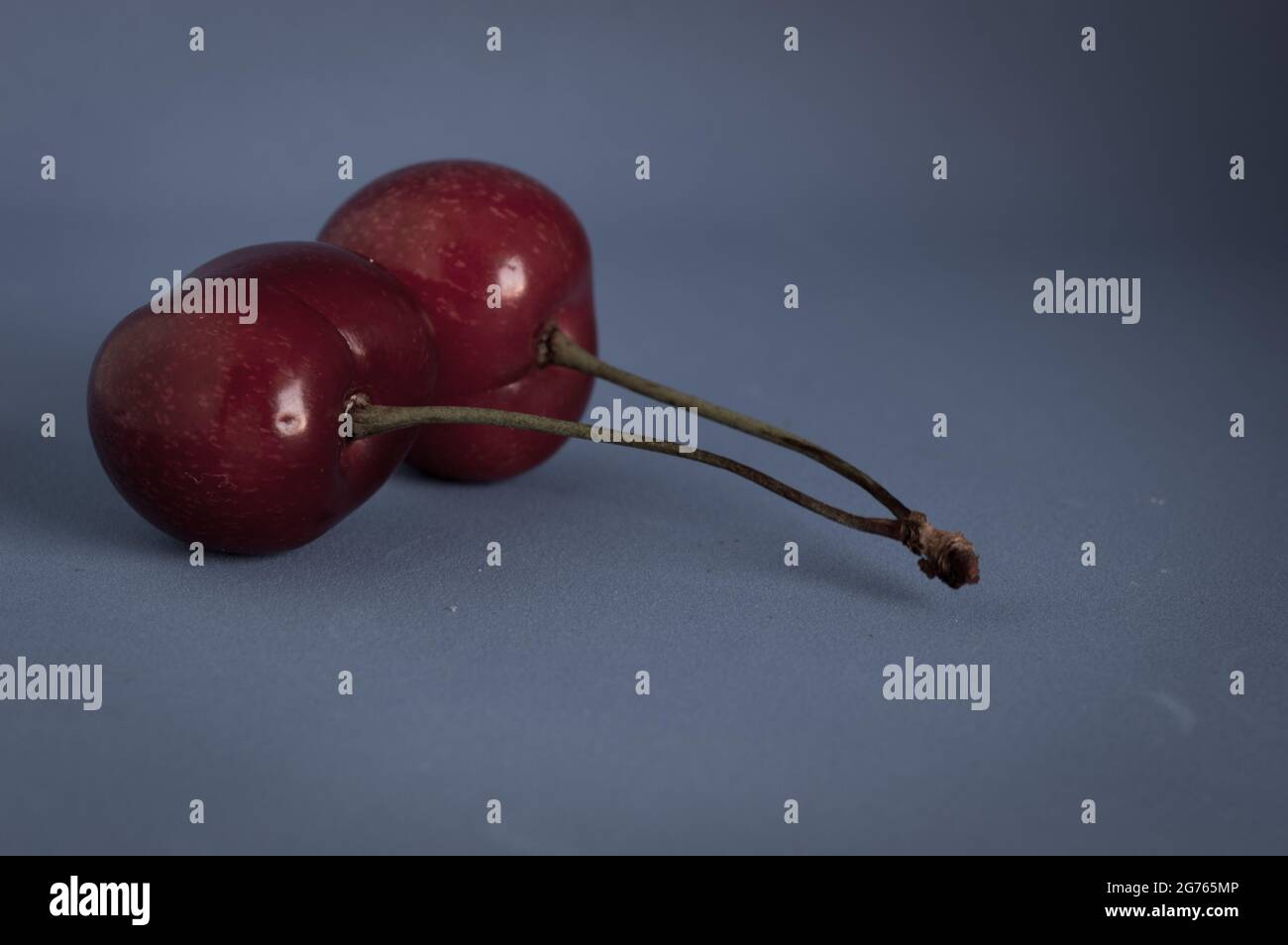 Cerises douces et noires fraîches avec tige de Dalmatie, isolées et artistiques, fruits d'été Banque D'Images