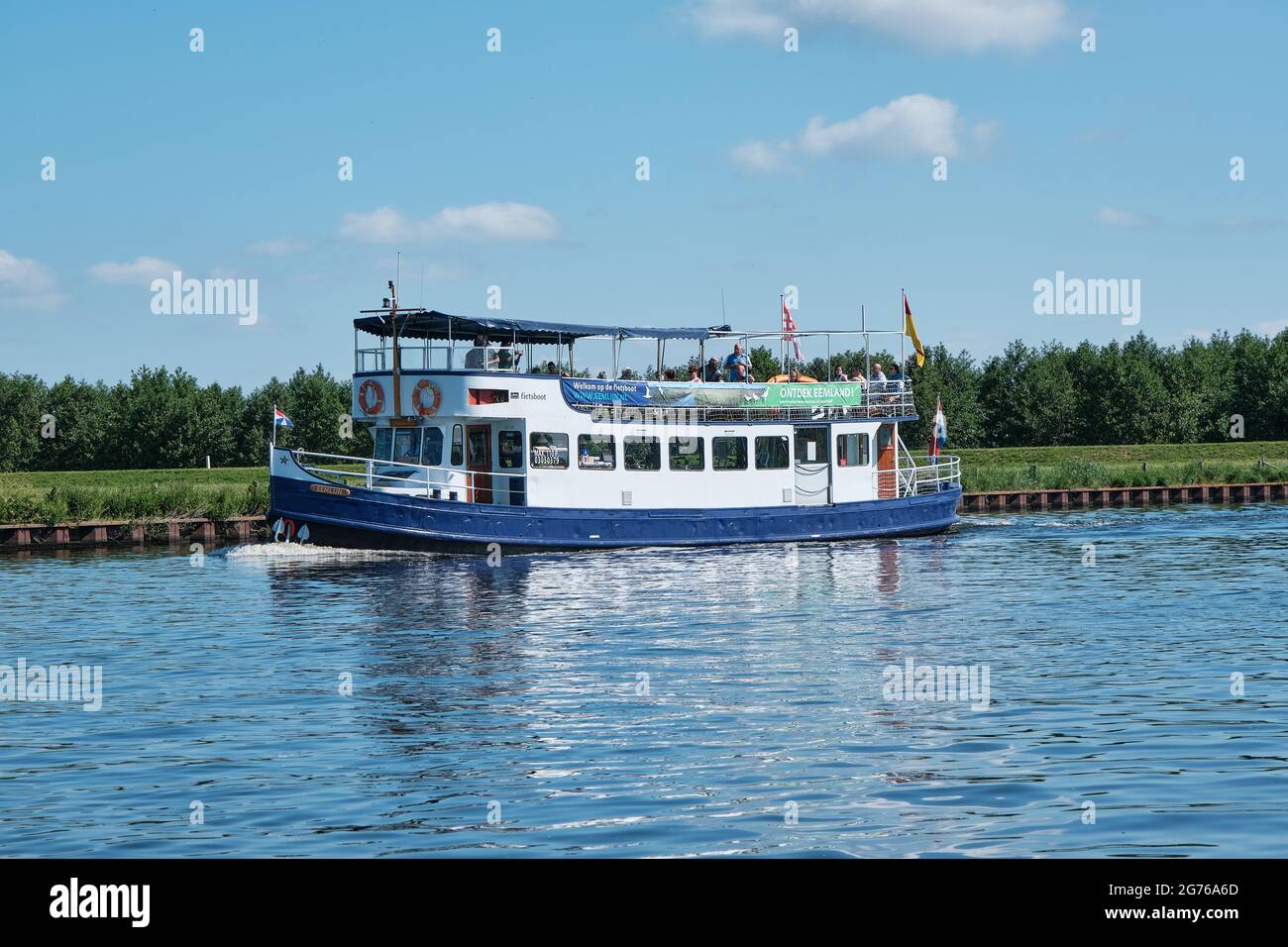 Amersfoort, Hoogland, pays-Bas 13 juin 2021, bateau à vélo, ferry eemland sur la rivière EEM avec des passagers et une digue et un ciel bleu dans le Banque D'Images