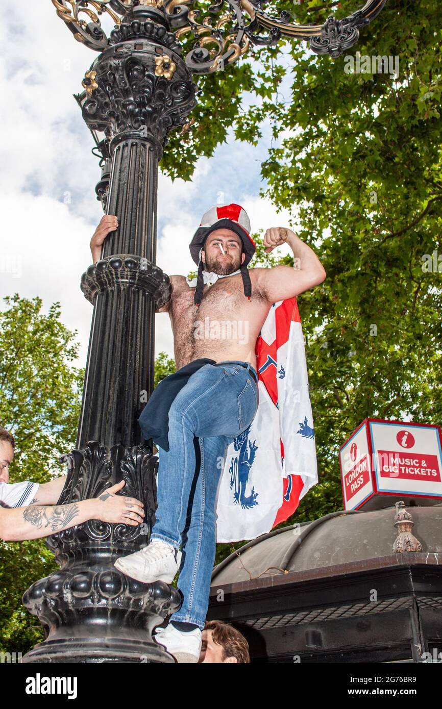 leicester Station, Londres, Angleterre. 11 juillet 2021. Les fans grimpent en hauteur tout en chantant des slogans anglais avant le match. Credit: Stefan Weil/Alay Live News Banque D'Images