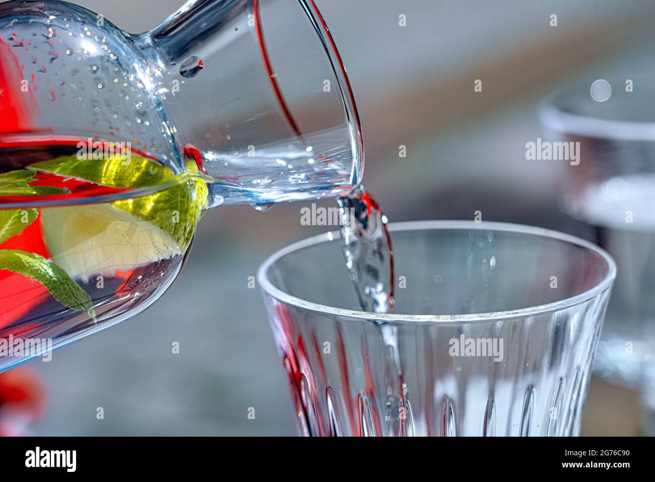 L'eau de citron d'une bouteille est versée dans un verre Banque D'Images