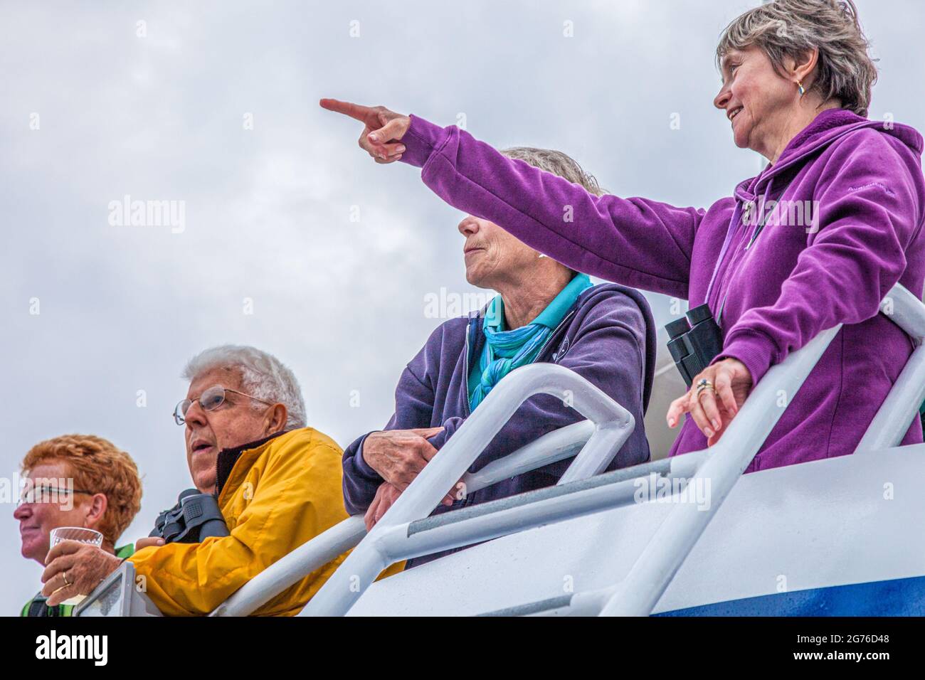 Touristes à bord de l'un des bateaux de croisière Dolphin sur une observation des baleines, Cape Cod, Massachusetts. Une femme a repéré une baleine. Banque D'Images