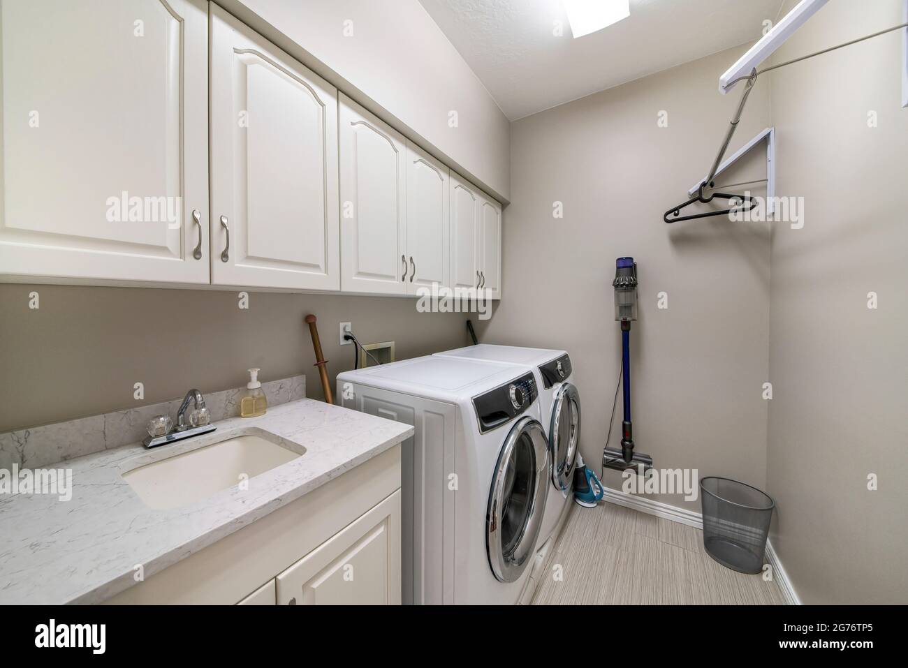 Intérieur de la buanderie avec lave-linge à chargement frontal et armoires murales Banque D'Images