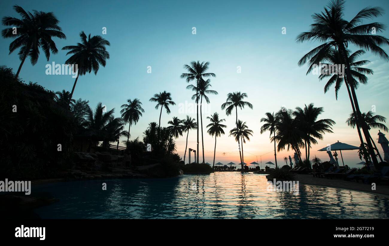 Vue sur la plage de palmiers tropicaux au beau crépuscule. Banque D'Images