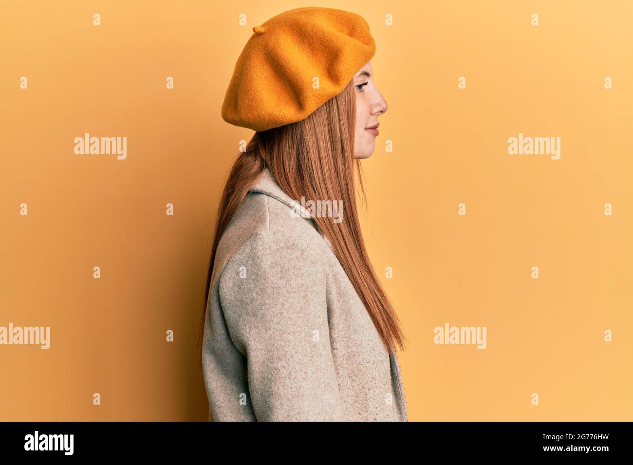 Jeune femme irlandaise portant un look français avec un béret regardant à côté, détendez-vous posture profil avec visage naturel avec un sourire confiant. Banque D'Images