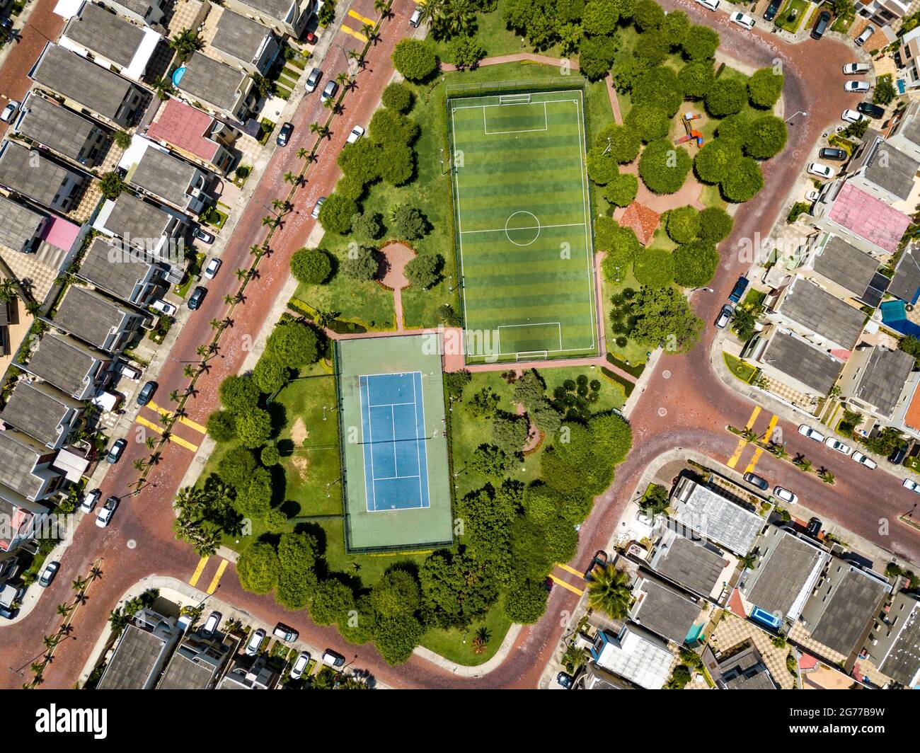 Un tir de drone de terrain de mini-football vide et un terrain de ténis entouré d'un parc et d'arbres dans une communauté fermée à l'extérieur de Guayaquil City, en Équateur. Banque D'Images