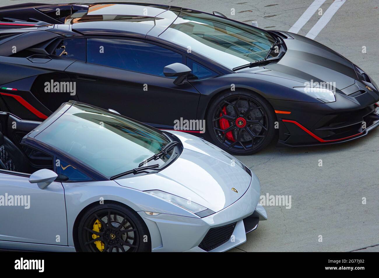Une Lamborghini Gallardo convertible et Lamborghini Aventador bénéficient de places de parking premium dans une zone exclusive. Banque D'Images