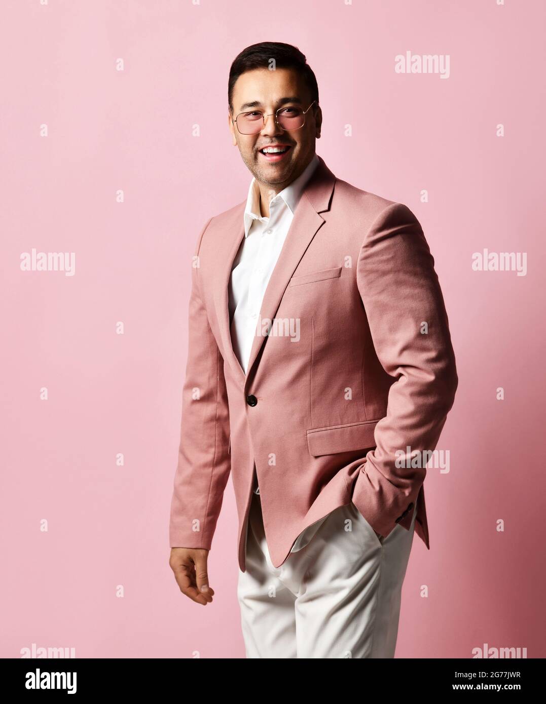 Portrait du jeune homme d'affaires brunet, marchand d'art charismatique dans les tribunes officielles de costume tenant la main dans la poche de pantalon Banque D'Images