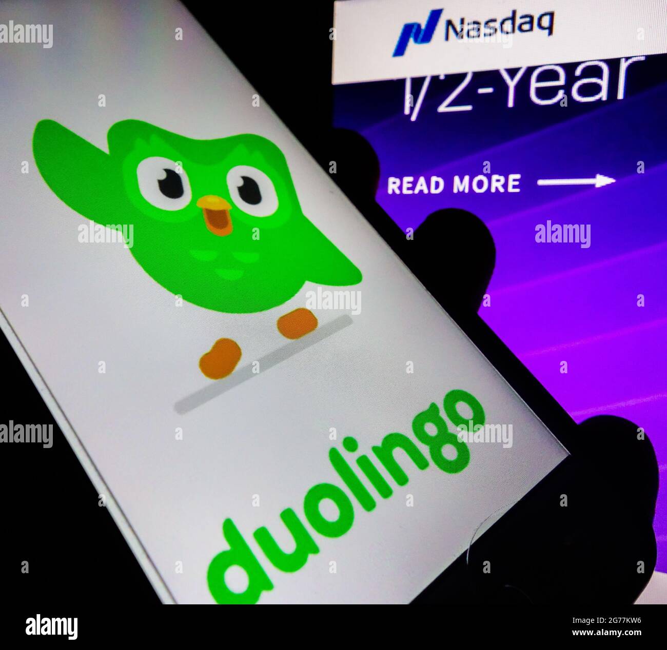 SAO PAULO, BRÉSIL - 01 juin 2021 : smartphone avec logo de l'application en langue Duolingo à l'écran et arrière-plan flou avec le site de bourse Nasdaq. Duol Banque D'Images