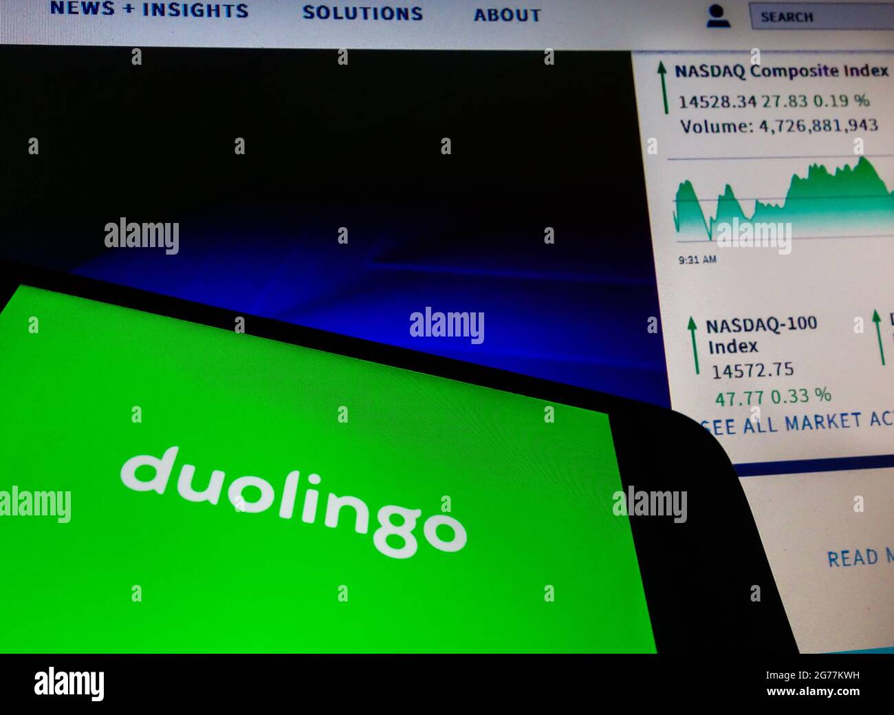 SAO PAULO, BRÉSIL - 01 mai 2021 : smartphone avec logo de l'application en langue Duolingo à l'écran et arrière-plan flou avec le site de bourse Nasdaq. Duol Banque D'Images