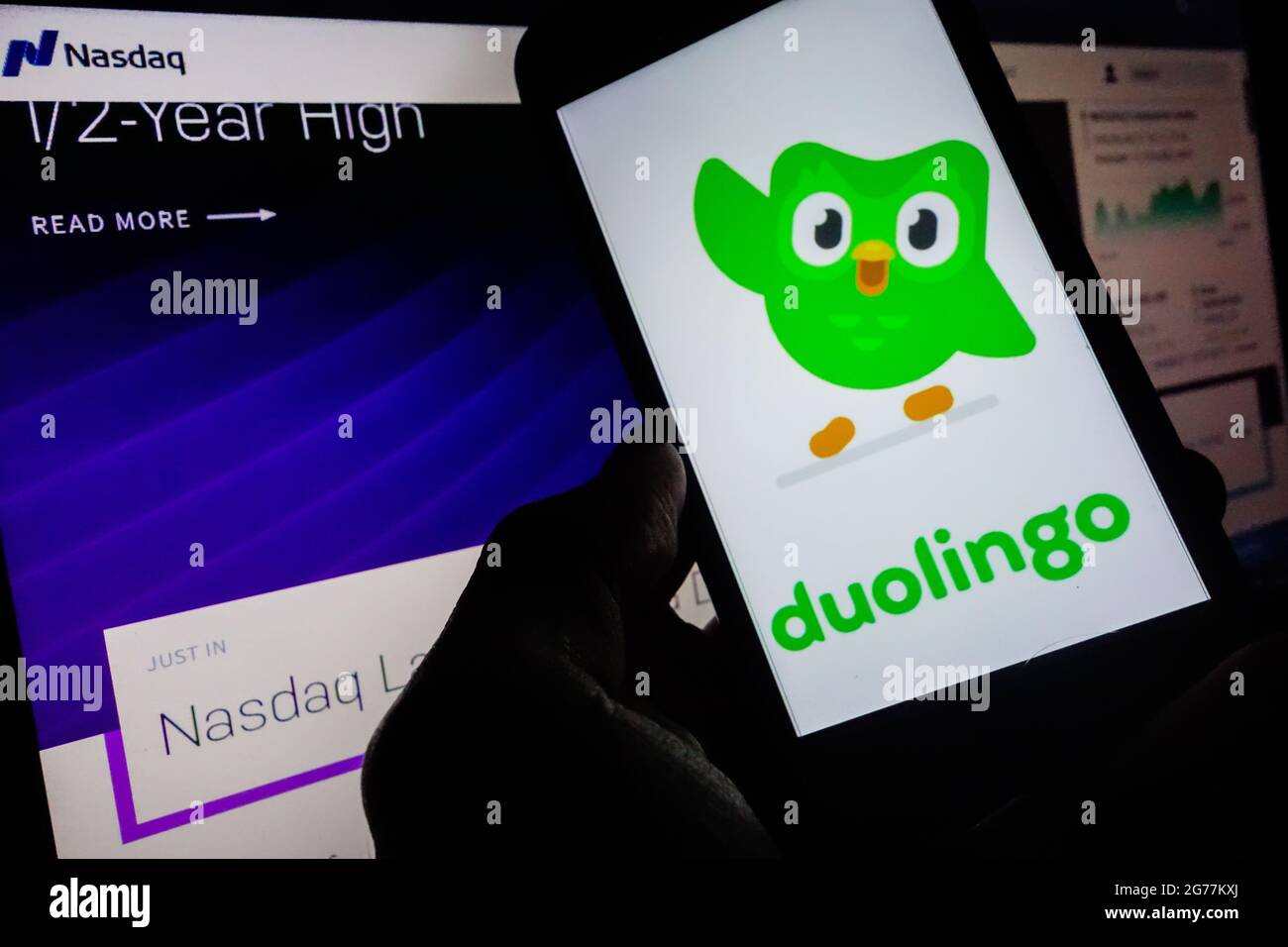 SAO PAULO, BRÉSIL - 01 juin 2021 : smartphone avec logo de l'application en langue Duolingo à l'écran et arrière-plan flou avec le site de bourse Nasdaq. Duol Banque D'Images