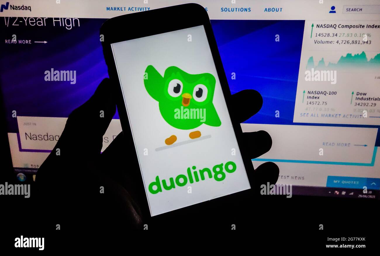 SAO PAULO, BRÉSIL - 30 juin 2021 : smartphone avec logo de l'application en langue Duolingo à l'écran et arrière-plan flou avec le site de bourse Nasdaq. Duol Banque D'Images