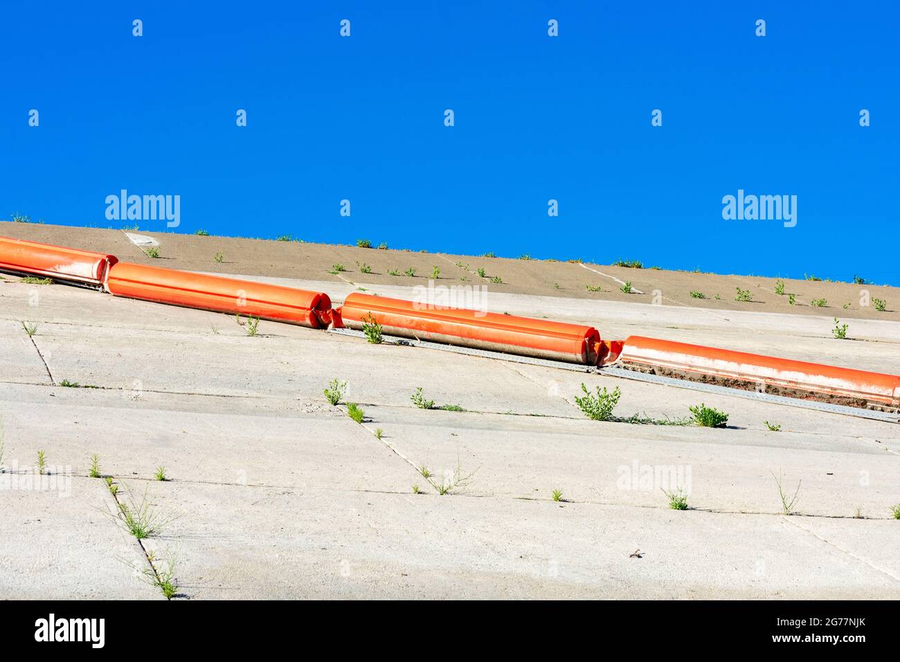 Flèche flottante orange pour débris, barrière sur le mur du barrage en béton du réservoir pendant la saison sèche. Banque D'Images