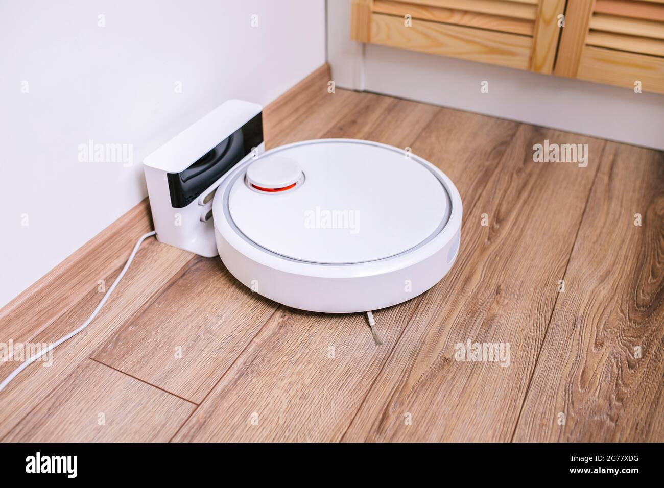 Aspirateur-robot dans le coin de la pièce sur la base de recharge Photo  Stock - Alamy