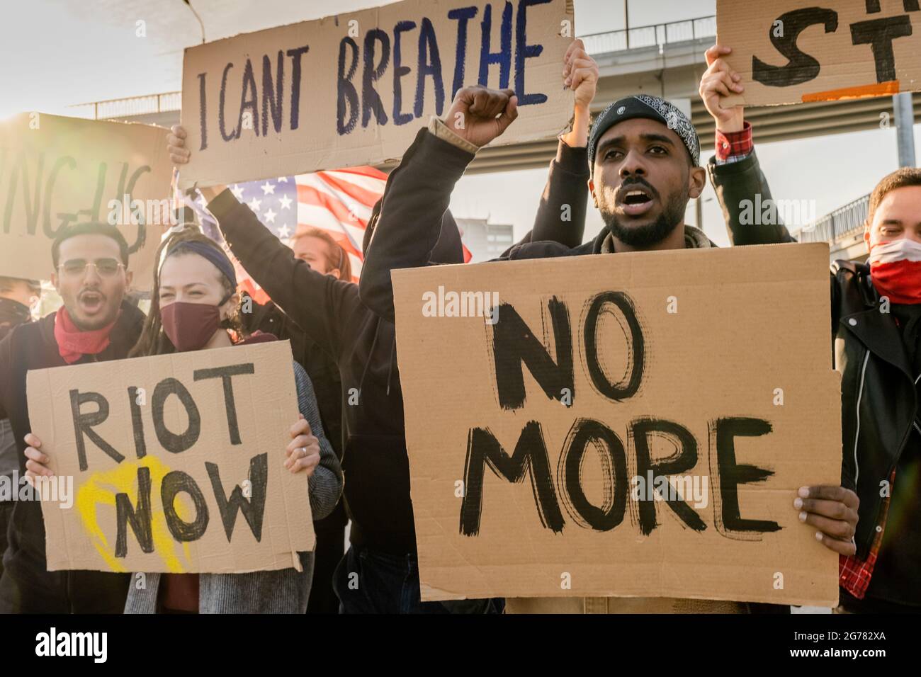Groupe de rébellion de jeunes multiethniques avec des banderoles qui élèvent des poings et crient dans la rue pendant le rassemblement Banque D'Images