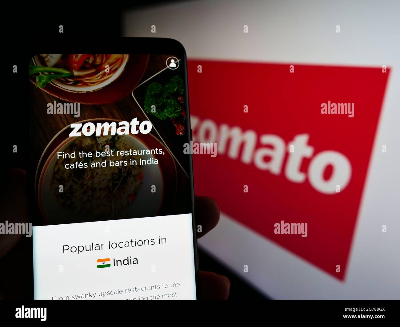 Personne tenant le téléphone portable avec la page web de la compagnie indienne de commande de nourriture en ligne Zomato sur l'écran devant le logo. Concentrez-vous sur le centre de l'écran du téléphone. Banque D'Images