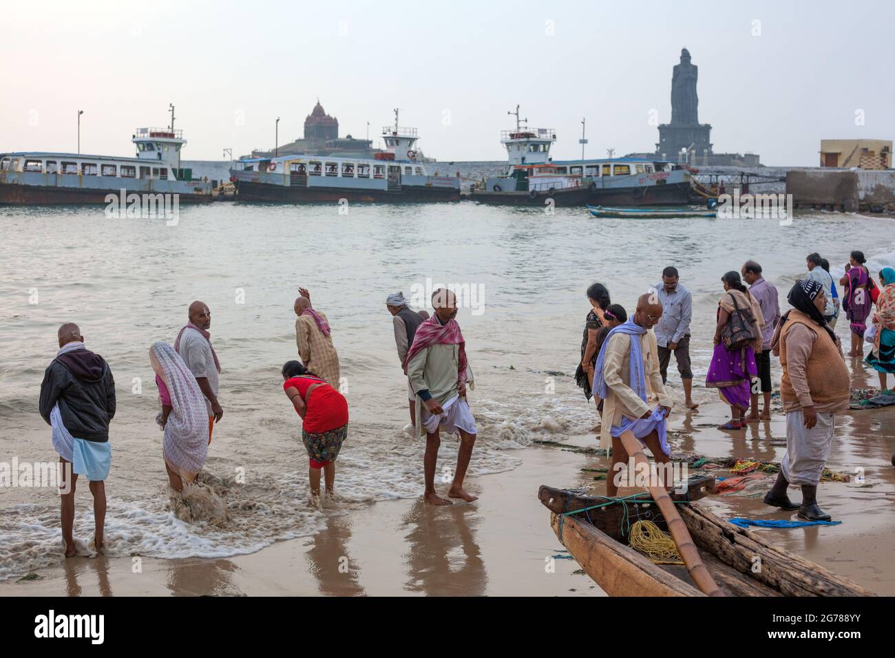 Les adorateurs hindous se baignent tôt le matin dans l'océan au monument commémoratif de Vivekananda Rock et à la statue de Thiruvalluvar, Kanyakumari, Tamil Nadu, Inde Banque D'Images