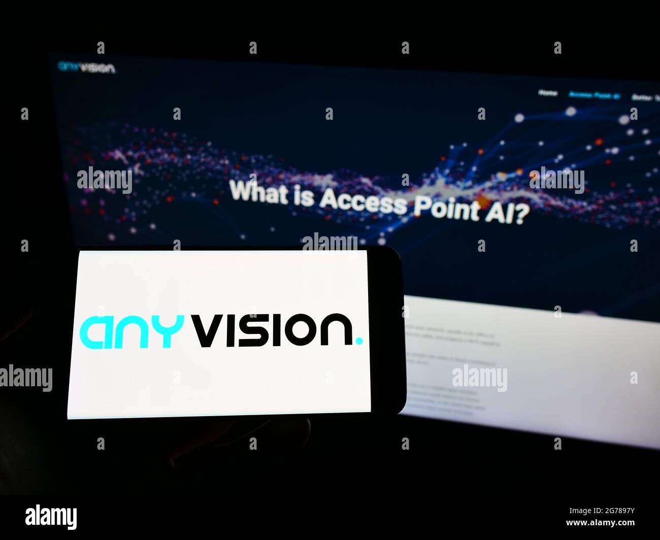 Personne tenant un téléphone portable avec le logo de la société AnyVision Interactive technologies Ltd. À l'écran en face de la page Web. Mise au point sur l'affichage du téléphone. Banque D'Images