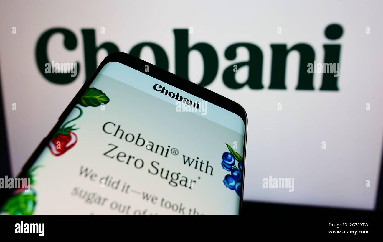 Smartphone avec le site Web de l'entreprise américaine de yaourt tendu Chobani LLC à l'écran devant le logo d'affaires. Faites la mise au point dans le coin supérieur gauche de l'écran du téléphone. Banque D'Images