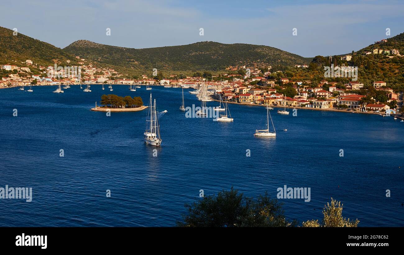 Îles Ioniennes, Ithaka, île d'Odysseus, capitale, Vathi, baie de Vathi, plusieurs bateaux à voile, l'îlot Lazareto, Vathi et la gamme verte de collines derrière Vathi, ciel bleu clair avec des nuages individuels, mer bleu profond Banque D'Images