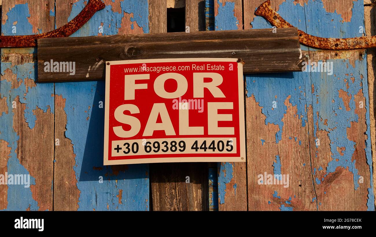 Îles Ioniennes, Ithaca, île d'Odysseus, nord-ouest, village de montagne Exogi, Volets bleus altérés, panneau imprimé indiquant « À VENDRE » Banque D'Images