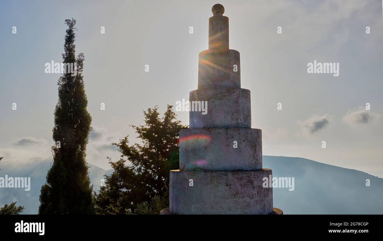 Îles Ioniennes, Ithaca, île d'Odysseus, nord-ouest, village de montagne Exogi, Pyramides d'Exogi, oeuvre du millionnaire excentrique Ioannis Papadopulos. Parents tombe. Symboles freemason, construits dans les années 1930, pyramide rétro-éclairée, couleurs spectrales dans le sunbeam, ciel bleu clair à blanc, arbre mince sur la gauche Banque D'Images