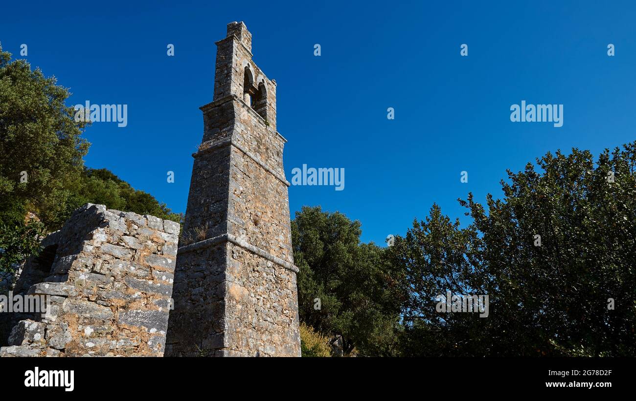 Iles Ioniennes, Ithaka, île d'Odysseus, Vathi, quartier Perachori, il se trouve sur une pente de montagne boisée, église, clocher en brique haute et étroite, vue grand angle, ciel bleu vif Banque D'Images