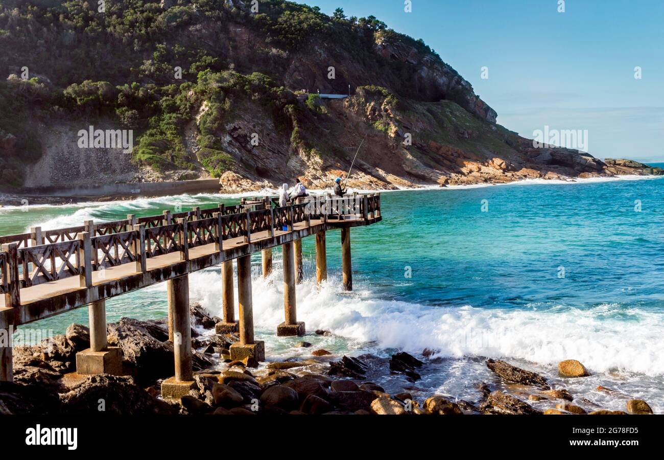 Pier at Beach - jetée avec pêcheurs à Victoria Bay dans l'ouest du Cap Afrique du Sud - plage de surf populaire pour les surfeurs dans tout le pays. Banque D'Images