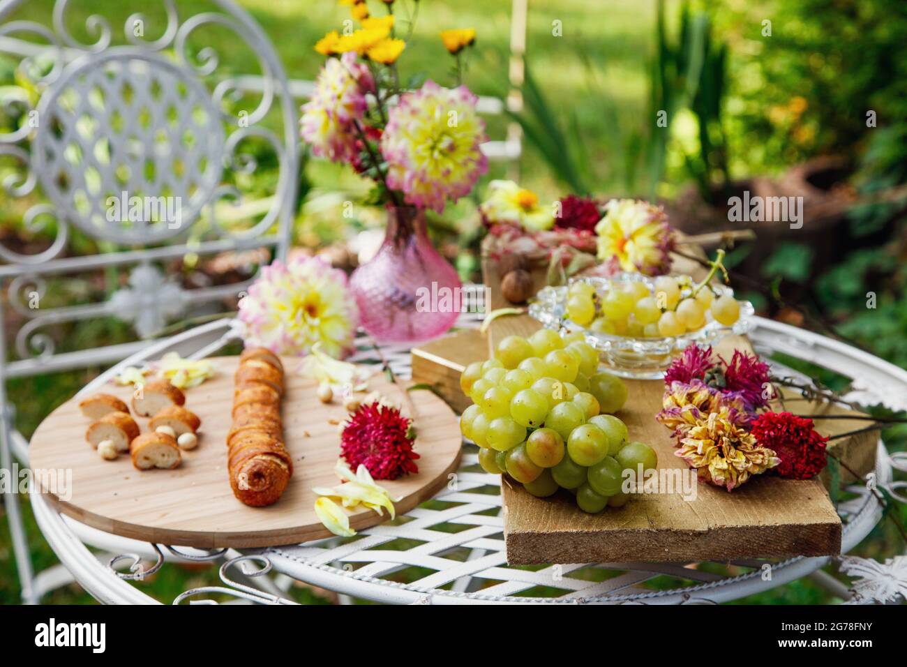 Table de jardin, pain, raisins, fleurs, encore la vie, Romantique, charme, cuisine française, méditerranéenne Banque D'Images