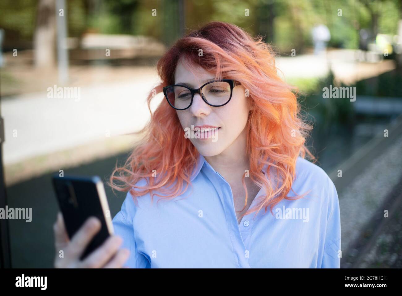 femme de direction regardant son téléphone cellulaire à l'extérieur Banque D'Images