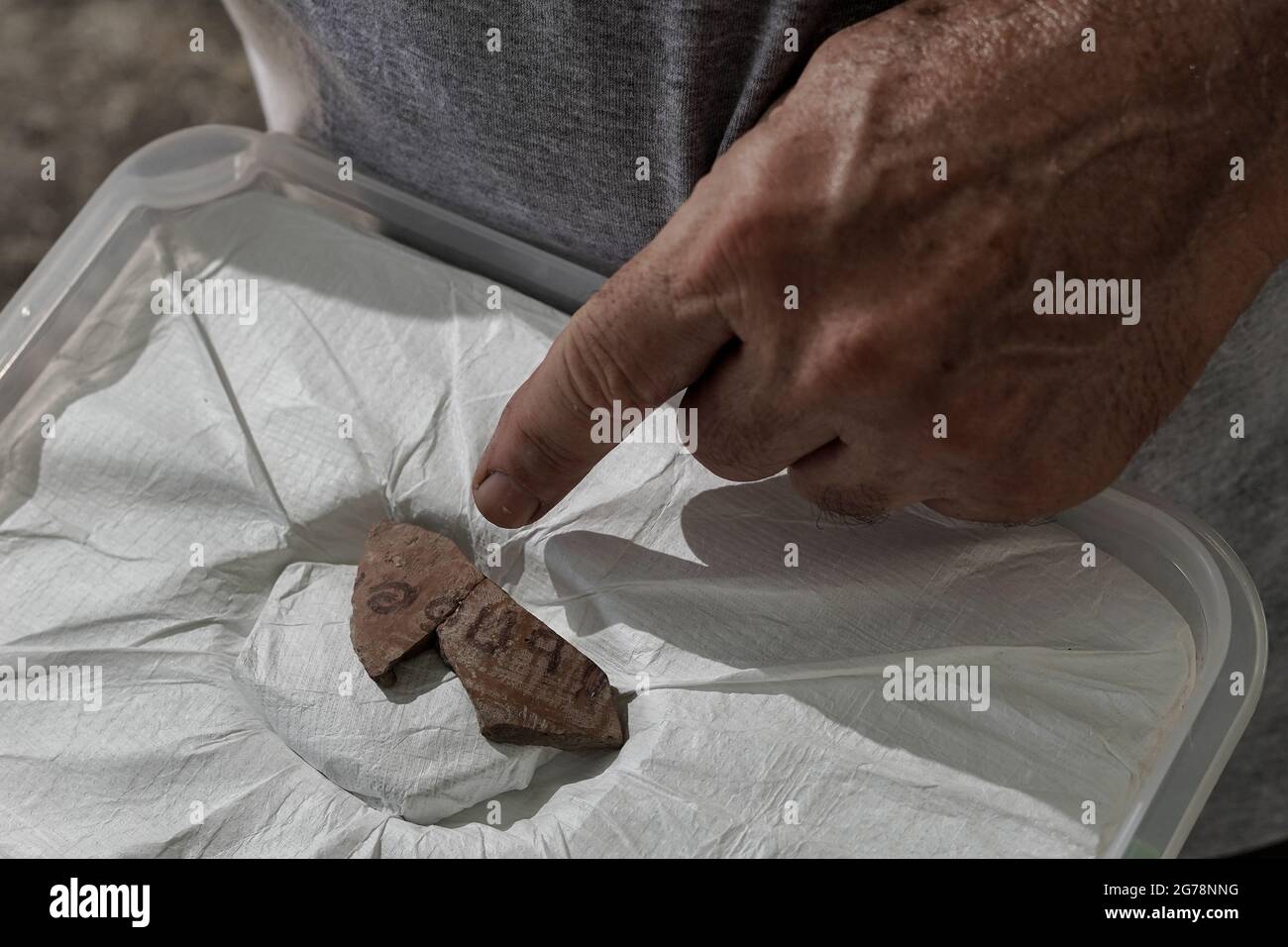 Khirbet a Rai, Israël. 12 juillet 2021. L'archéologue Yosef Garfinkel de l'Université hébraïque inspecte un artefact, sur le site de Khirbet a Rai dans les contreforts judaïens, précédemment identifié comme la ville biblique Philistine de Ziklag de l'époque du roi David, L'endroit où David a trouvé refuge en fuyant le roi Saül et d'ici est allé à Hébron pour être oint comme roi. Cette inscription sans précédent à l'encre de script Proto Canaanite sur un bateau de poterie porte le nom Jerubbaal, le nom du juge Gideon Ben Yoash du Livre des juges. Les conclusions de l'excavation Banque D'Images