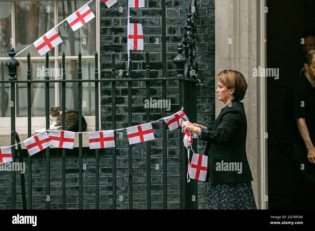 LONDRES 12 juillet 2021. Un membre du personnel enlève le bunkting d'Angleterre attaché sur les rails de Downing Street un jour l'équipe nationale de football d'Angleterre avait perdu la finale de l'UEFA Euro 2020 sur des sanctions contre l'Italie à Wembley le dimanche 11 juillet. Les joueurs d'Angleterre Marcus Rashford, Jadon Sancho et Bukayo Saka ont été ciblés sur les médias sociaux avec des abus raciaux après avoir manqué leurs sanctions lors de la fusillade qui a porté la victoire à l'équipe italienne. Credit amer ghazzal/Alamy Live News Banque D'Images