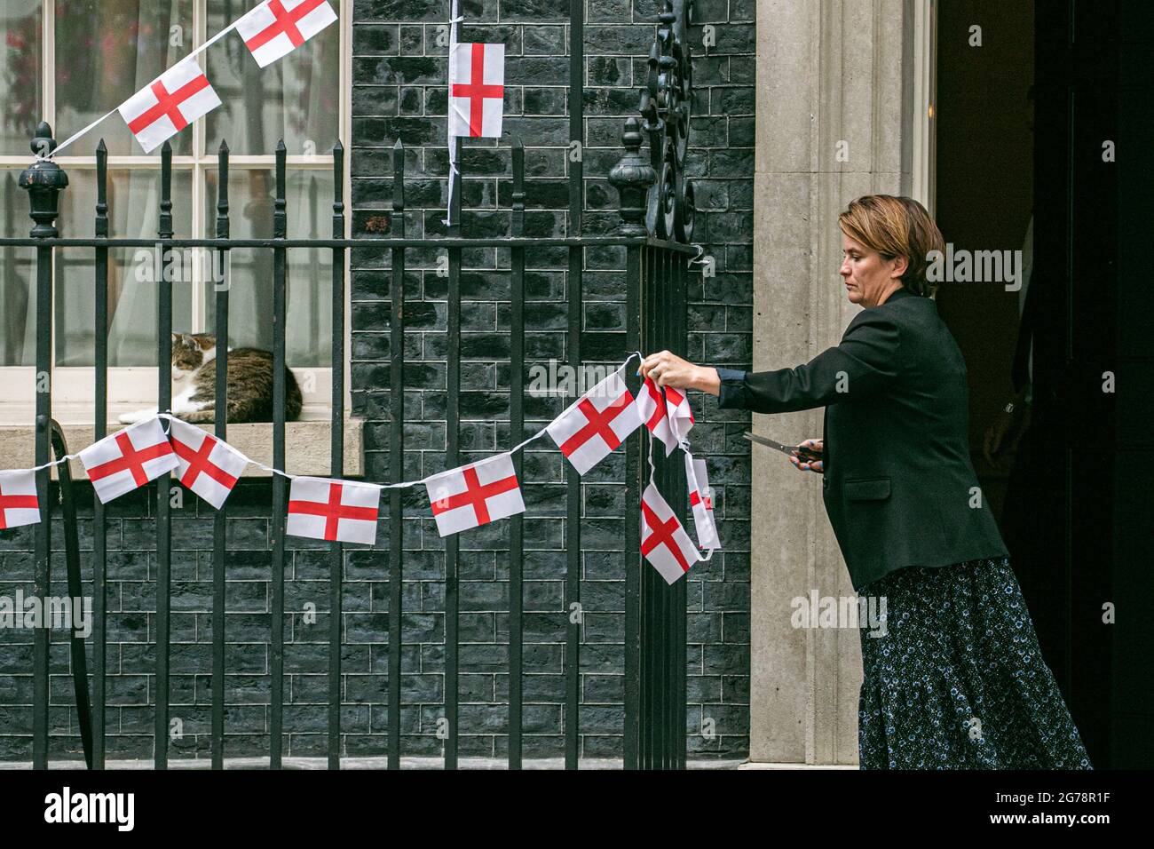 LONDRES 12 juillet 2021. Un membre du personnel enlève le bunkting d'Angleterre attaché aux rails de Downing Street un jour l'équipe nationale de football d'Angleterre avait perdu la finale de l'UEFA Euro 2020 sur des sanctions contre l'Italie à Wembley le dimanche 11 juillet. Les joueurs d'Angleterre Marcus Rashford, Jadon Sancho et Bukayo Saka ont été ciblés sur les médias sociaux avec des abus raciaux après avoir manqué leurs sanctions lors de la fusillade qui a porté la victoire à l'équipe italienne. Credit amer ghazzal/Alamy Live News Banque D'Images