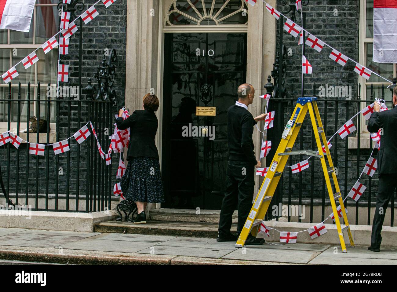 LONDRES 12 juillet 2021. Les membres du personnel délèvent le bunkting d'Angleterre autour de la porte du 10 Downing Street un jour l'équipe nationale de football d'Angleterre avait perdu la finale de l'UEFA Euro 2020 pour des sanctions contre l'Italie à Wembley le dimanche 11 juillet. Les joueurs d'Angleterre Marcus Rashford, Jadon Sancho et Bukayo Saka ont été ciblés sur les médias sociaux avec des abus raciaux après avoir manqué leurs sanctions lors de la fusillade qui a porté la victoire à l'équipe italienne. Credit amer ghazzal/Alamy Live News Banque D'Images