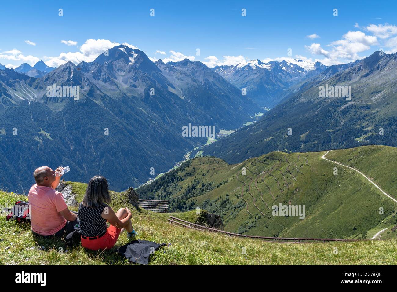 Europe, Autriche, Tyrol, Alpes de Stubai, les randonneurs s'assoient sur un pré de montagne avec une vue sur la vallée de Stubai Banque D'Images