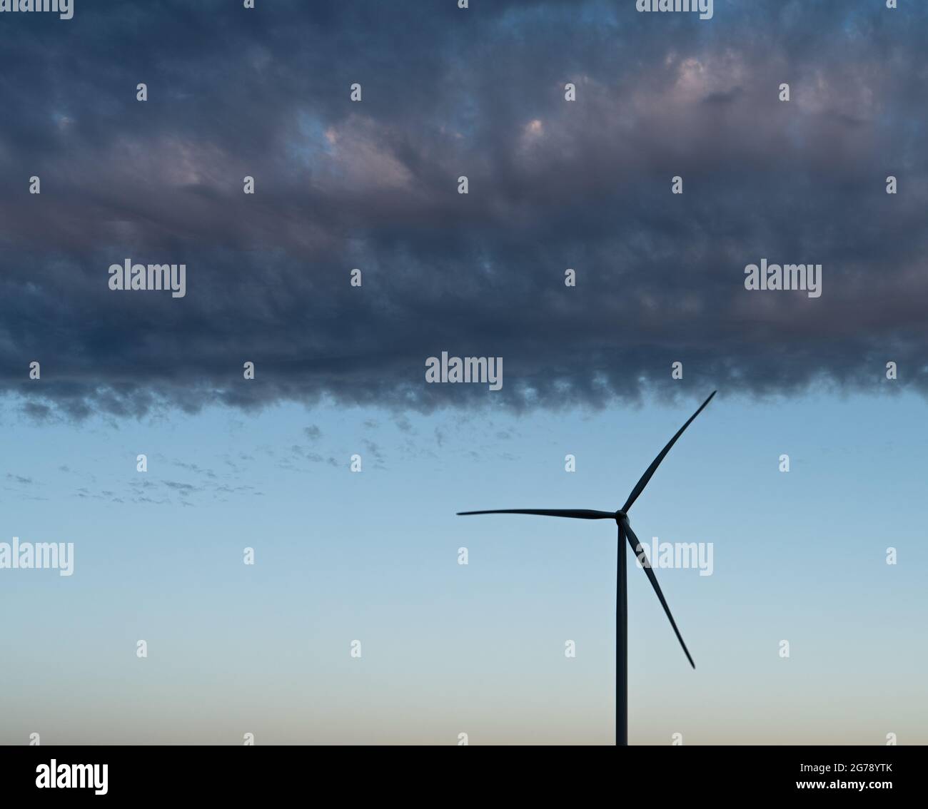 Silhouette moderne de turbine de moulin à vent sous les nuages sombres Banque D'Images