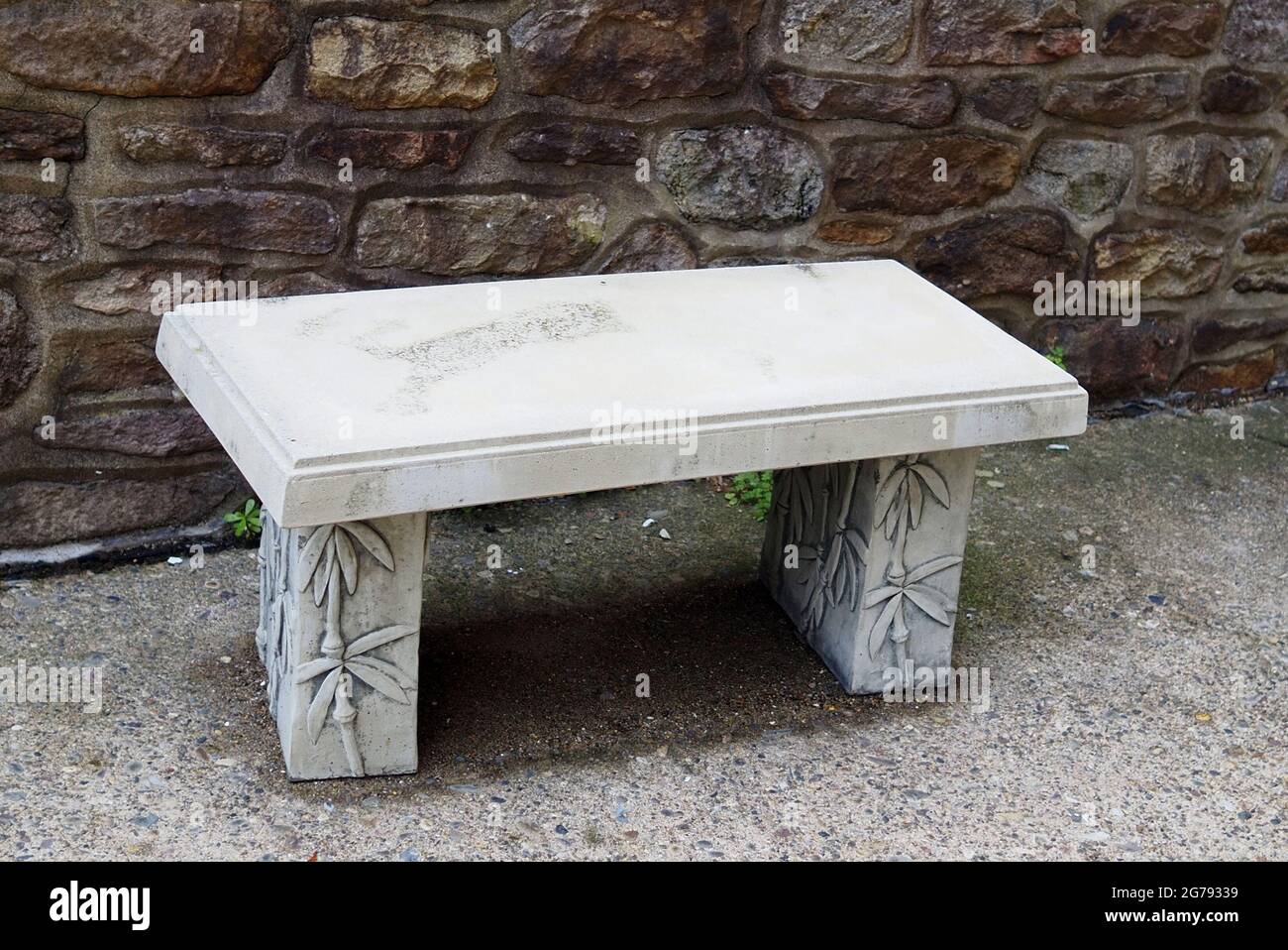 Le banc en béton est très durable, ii est dans une partie ombragée du parc. Banque D'Images