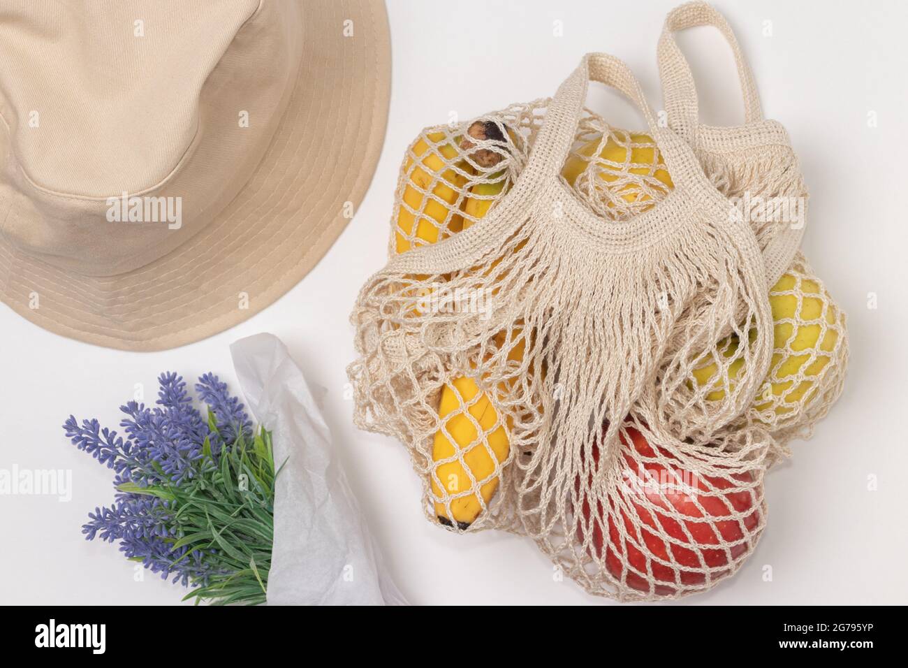 Sac fourre-tout d'épicerie réutilisable en coton avec fruits, fleurs et chapeau. Banque D'Images