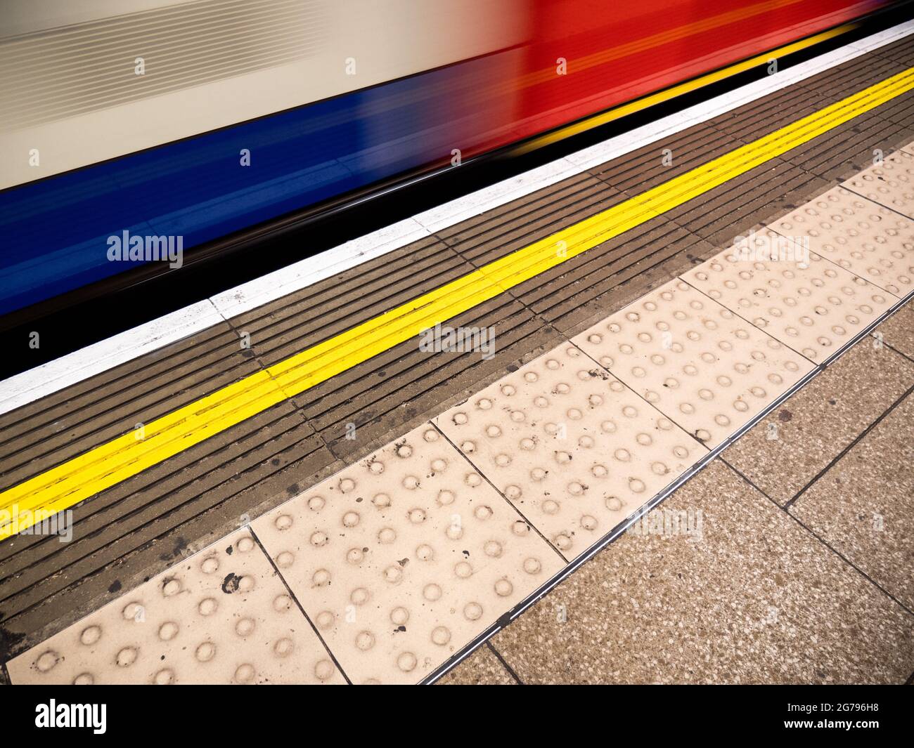 Métro de Londres. Un train de tubes Central Line passant rapidement la plate-forme pour créer un flou abstrait de mouvement d'arrière-plan. Banque D'Images