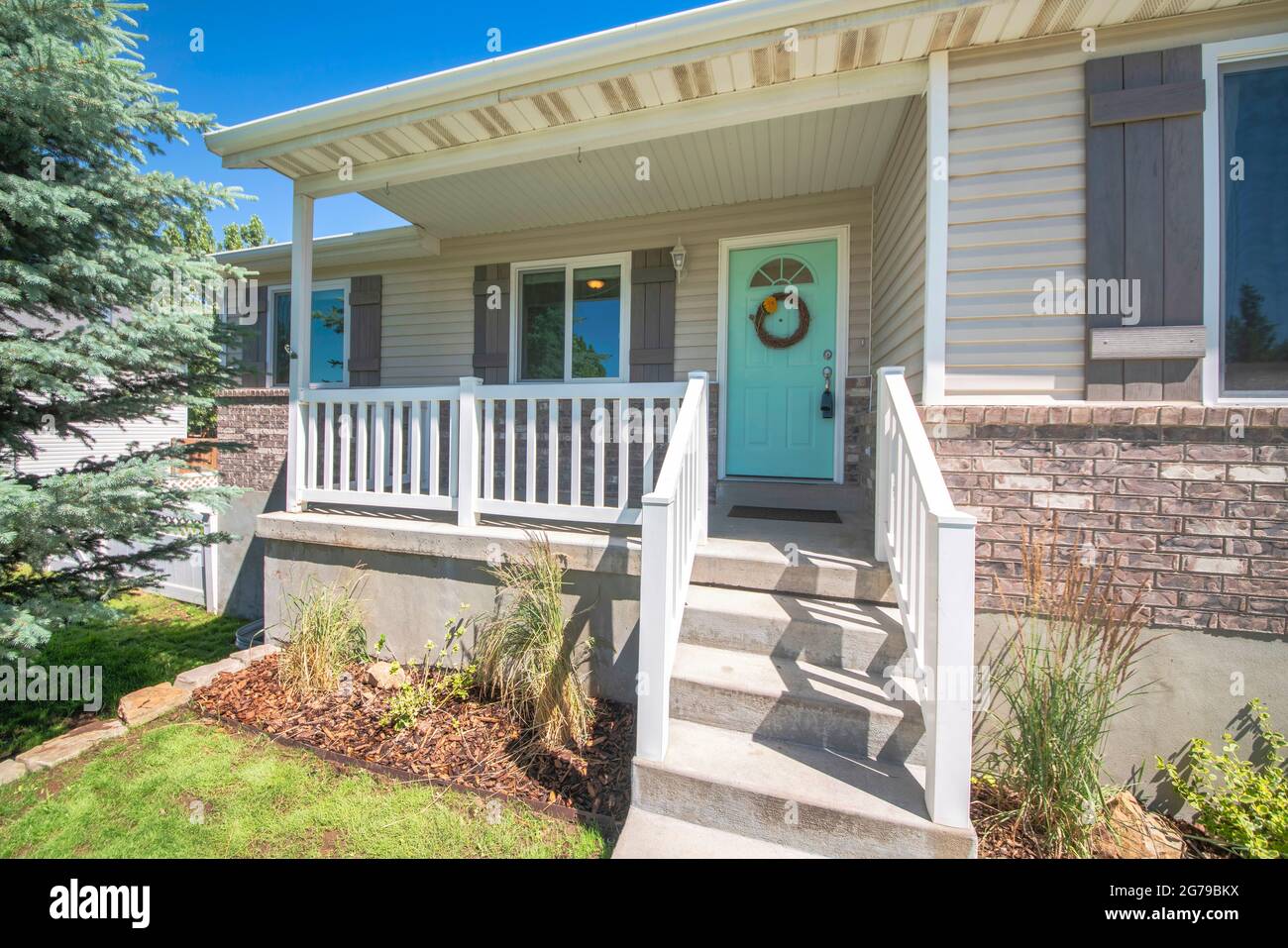 Extérieur d'une maison avec briques, porche surélevé et fenêtres à double vitrage Banque D'Images