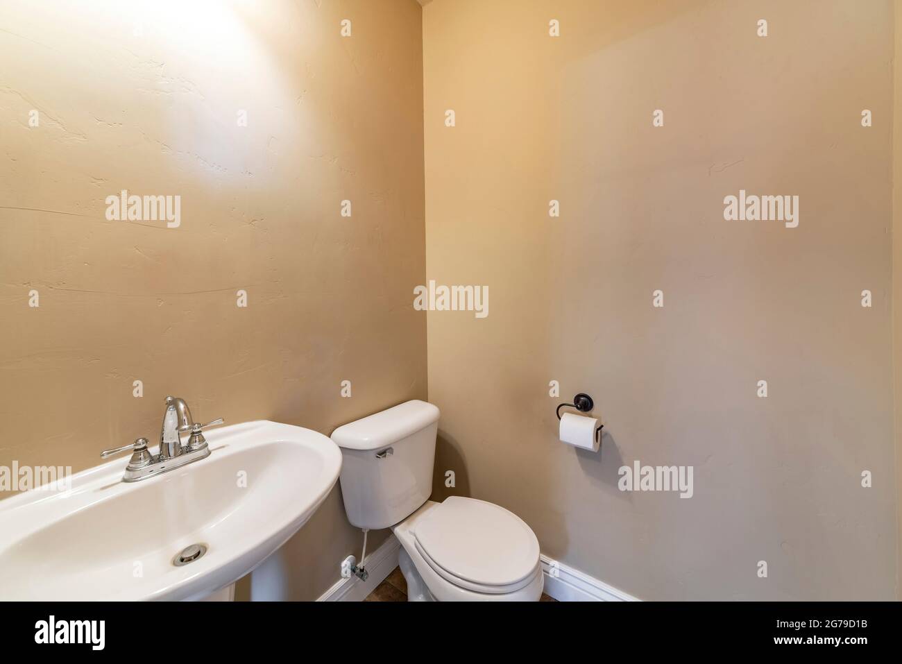 Salle d'eau avec murs de couleur ocre, cuvette de toilette et évier Banque D'Images