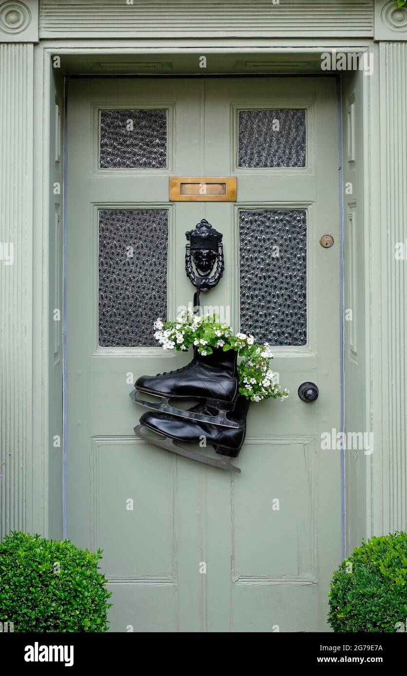 patins à glace insolite contenant à fleurs fixé à la porte d'entrée de la maison, nord de norfolk, angleterre Banque D'Images