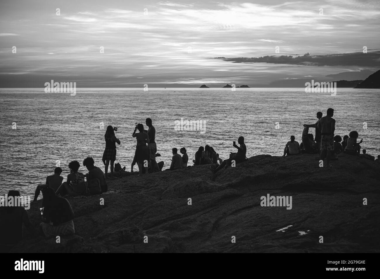 Un endroit magique: Les gens applaudissent quand le soleil se couche à Arpoador rocher avec vue sur la plage d'Ipanema et les montagnes de Morro Dois Irmaos et Leblon dans le dos. Appareil-photo: Leica M10 Banque D'Images