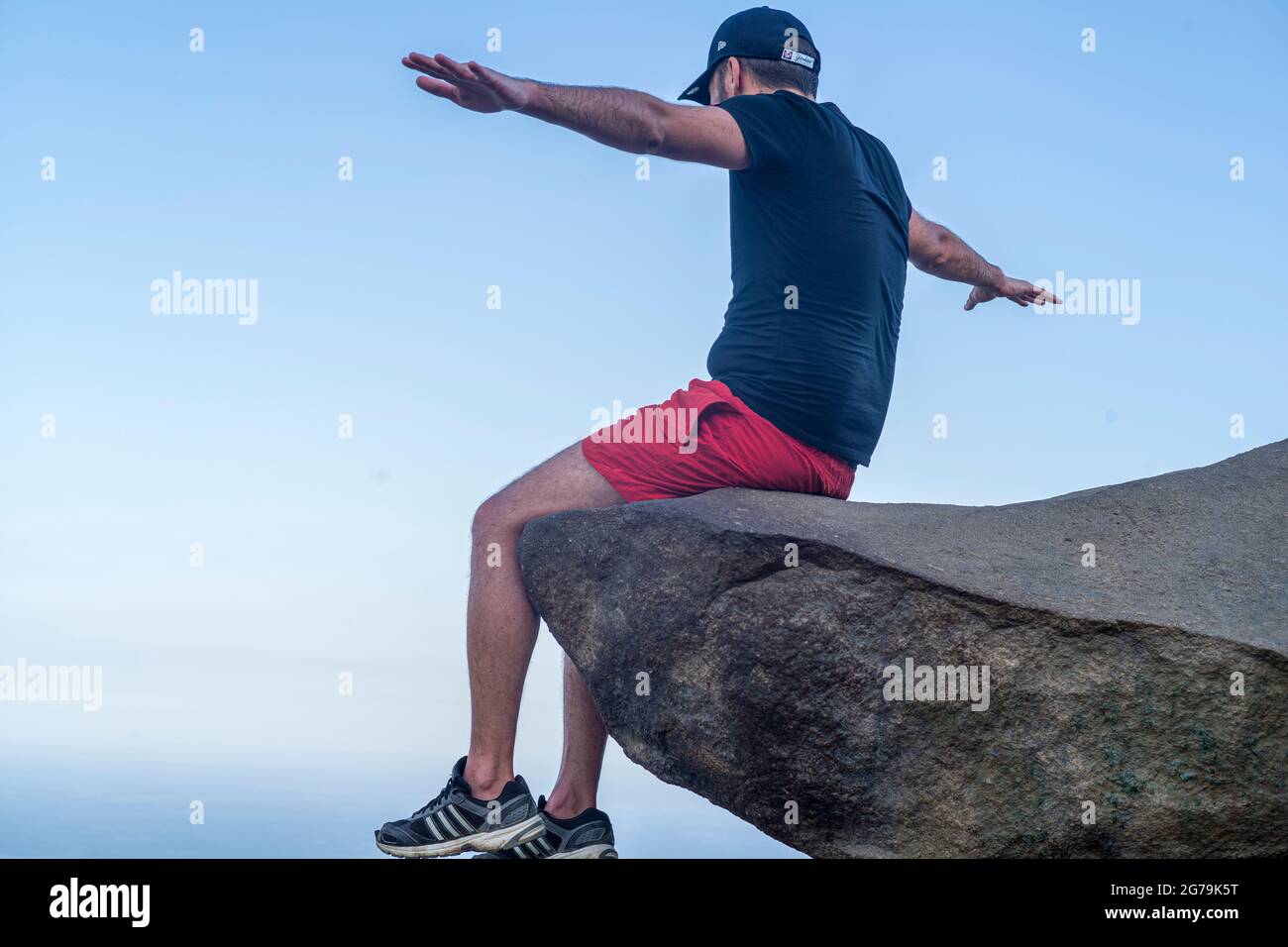 Un homme qui profite de la vue sur les plages sauvages depuis un rocher au sommet de la montagne Pedra do Telegrafo, Barra de Guaratiba, Rio de Janeiro, Brésil. Prise de vue avec Leica M10 Banque D'Images
