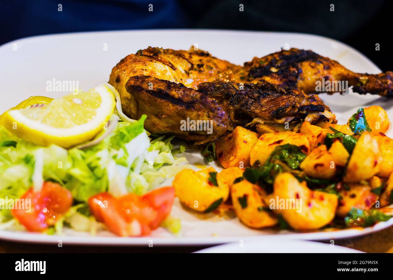 Authentique plat libanais, demi-poulet grillé avec salade et pommes de terre épicées. Banque D'Images