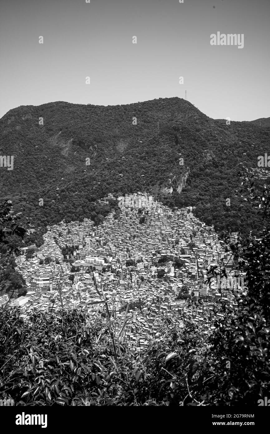 Vue en hauteur depuis le bord de la falaise de la colline de deux frères (dos irmaos) avec leica m10 sur le Rocinha Favela - dense bidonville plein de maisons en briques - à Rio de Janeiro, Brésil, du sommet de la montagne de Doi Irmaos. Banque D'Images