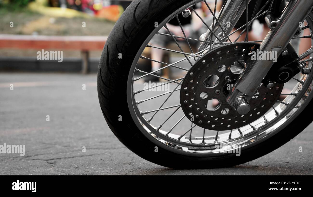 Gros plan sur une roue de moto sur un arrière-plan flou. Roue sur asphalte  - jour d'été Photo Stock - Alamy