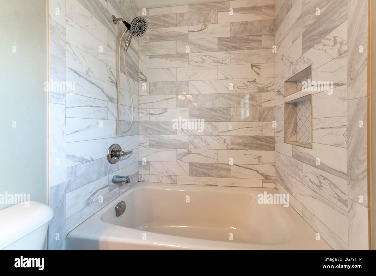 Salle de bains moderne avec baignoire en alcôve et carrelage en marbre Banque D'Images