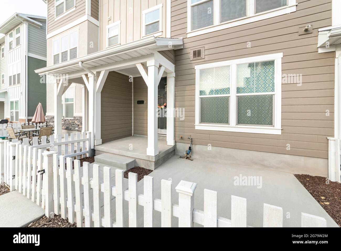 Extérieur d'une maison avec porte avant sombre avec couronne et clôture en bois et porte Banque D'Images