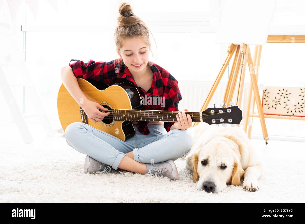 Jolie fille jouant de la guitare au chien Banque D'Images