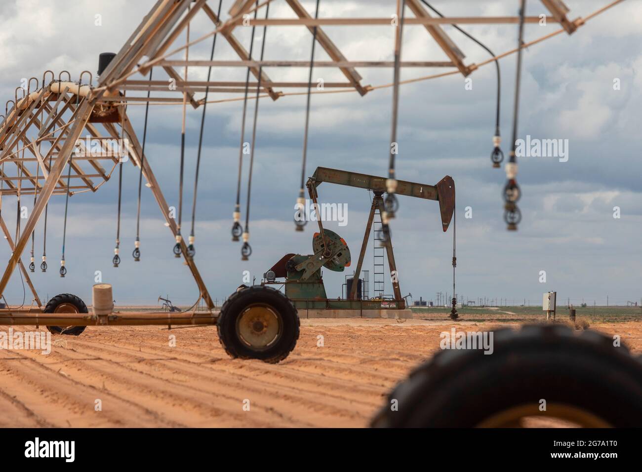 Plains, Texas - un puits de pétrole près de l'équipement d'irrigation sur les terres agricoles du bassin Permien. Banque D'Images